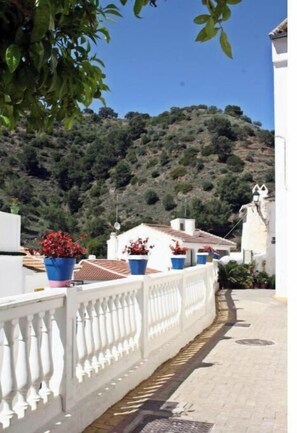 Stroll through the tranquil gardens, surrounded by lush greenery and a traditional building with a red-tiled roof.