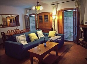 Relax in this inviting living room with a sofa, coffee table, dining area, and mirror.