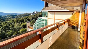A balcony with a wooden railing overlooking a scenic landscape. - Apt Quatre Saisons (Campos do Jordão)