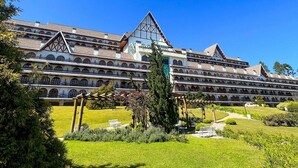 A large hotel with multiple balconies and a central atrium. - Apt Quatre Saisons (Campos do Jordão)