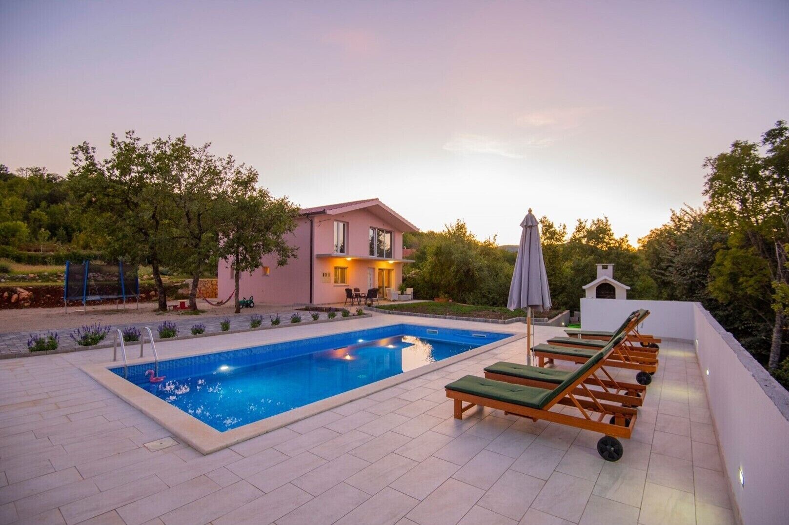 A swimming pool with lounge chairs and a building in the background.