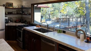 A modern kitchen with a large window, wooden beams, and a view of the outdoors. - Private river access. And 50+ acres (Three rivers)