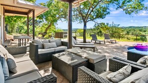 An outdoor patio with wicker furniture, a pool, and a scenic view. - Private Hill Country Retreat Near San Antonio (Bexar County)