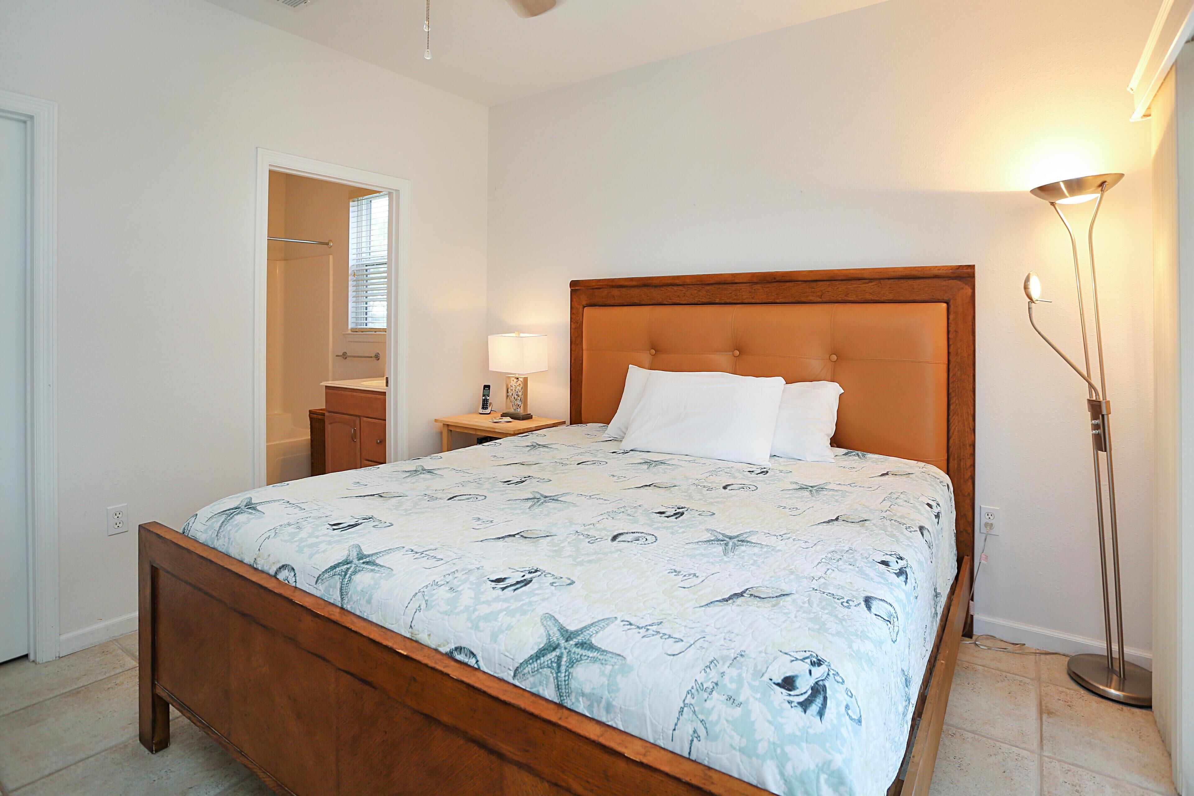 Une chambre à coucher avec un lit en bois, une table de chevet avec une lampe, une armoire et un lampadaire.