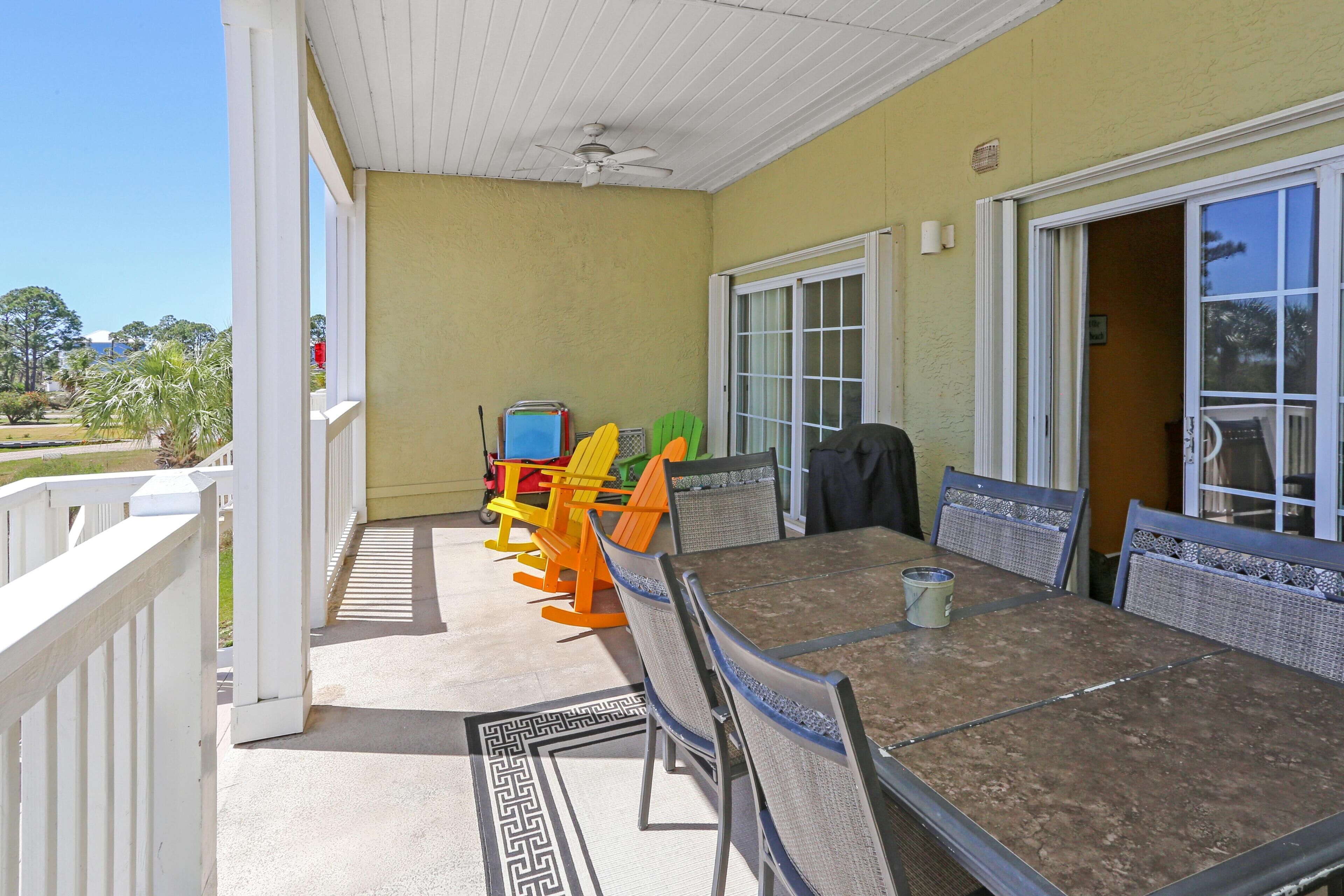 A covered patio with a table and chairs, a ceiling fan, and a view of the outdoors.