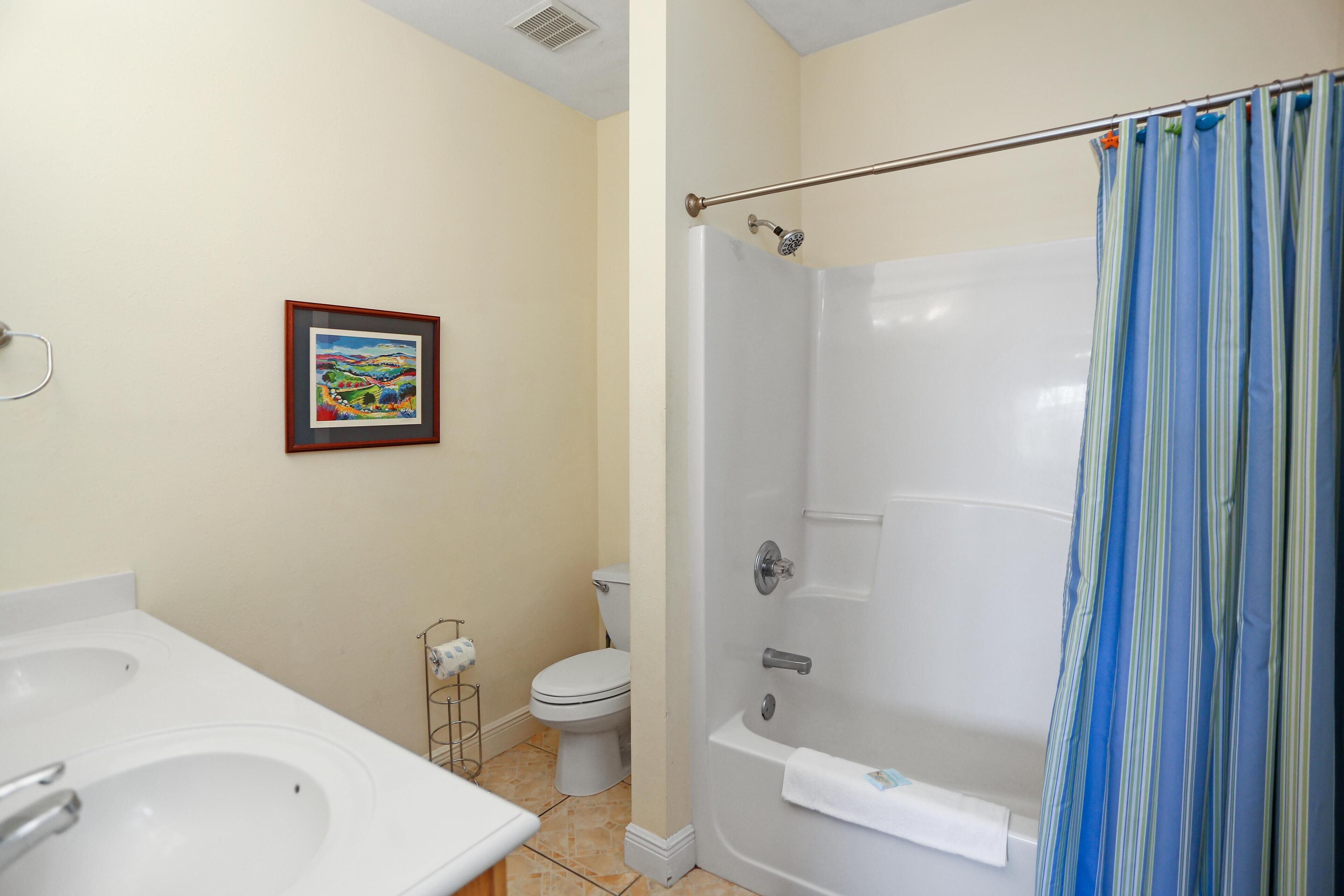 A bathroom with a bathtub, toilet, and two sinks.