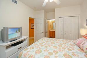 Relax in a cozy space with a comfortable bed, TV, and stylish doors leading to a bathroom.
