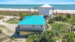 A coastal house with a blue roof, a balcony, and a separate white tower. - Brodie House (Port St. Joe)