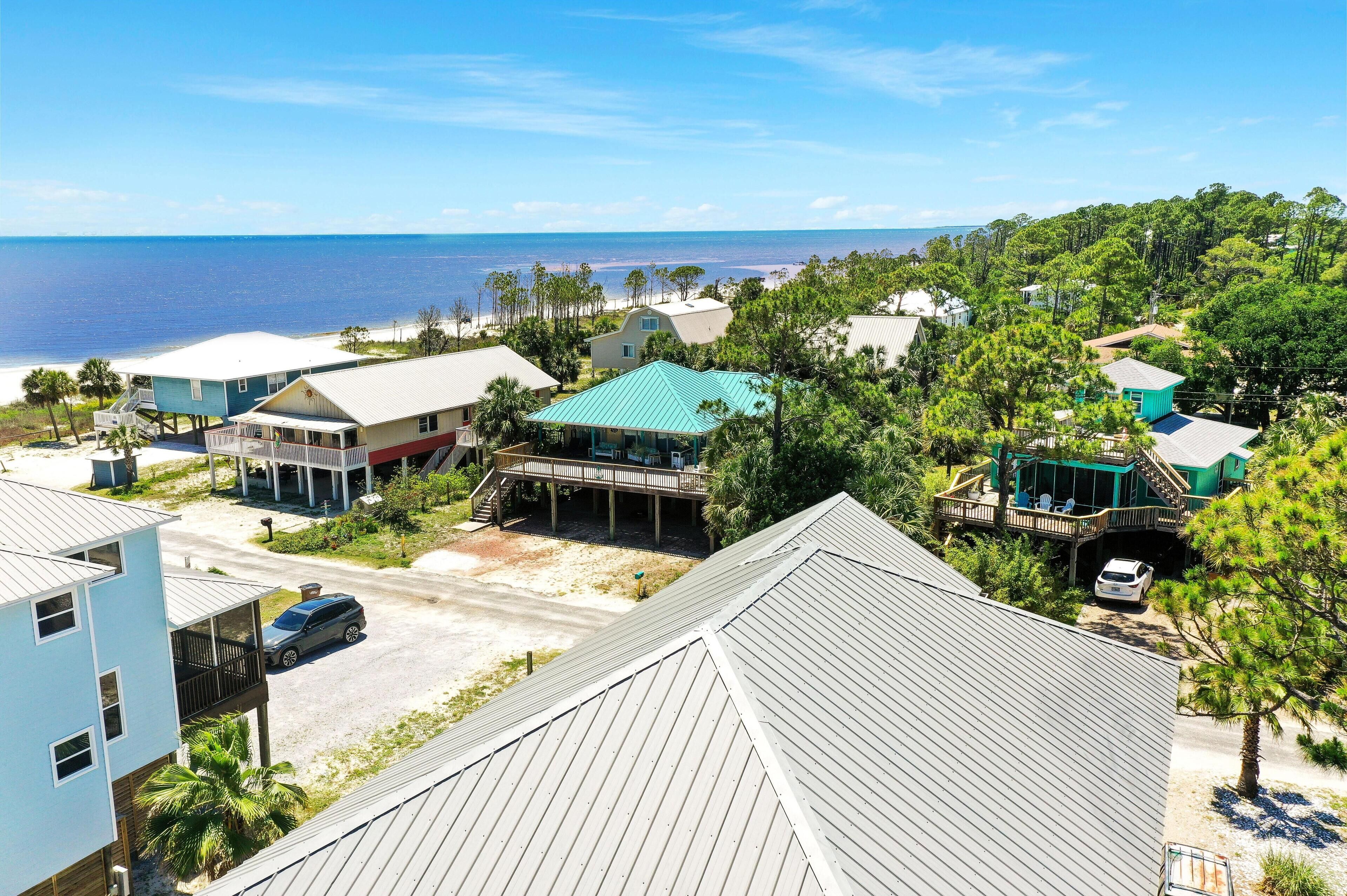 Una zona residencial costera con casas, una playa y vistas al océano.