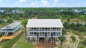 A two-story waterfront property with a dock, a covered deck, and a large open deck area. - Pelican Landing 3 (Port St. Joe)