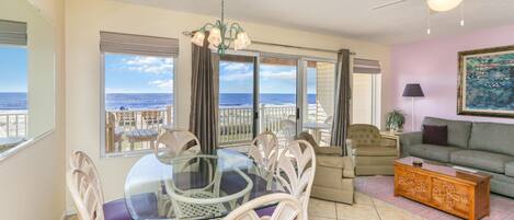 A spacious living room with a balcony, a dining area with a glass table, and a sofa.