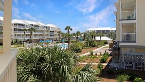 A hotel with multiple balconies, a pool area, and palm trees. - Sea Cliff B-2 (Port St. Joe)
