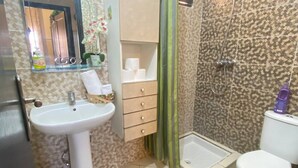 Ein Badezimmer mit Waschbecken, Toilette, Dusche und einem grünen Teppich.