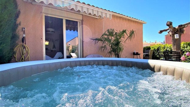A hot tub with a view of a building with a tiled roof and a door. - 5 minutes from the beach, quiet renovated house with wifi, air conditioning and jaccuzi (CANET EN ROUSSILLON)