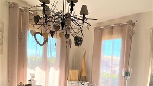 A dining area with a large table, white chairs, and a chandelier. - 5 minutes from the beach, quiet renovated house with wifi, air conditioning and jaccuzi (CANET EN ROUSSILLON)