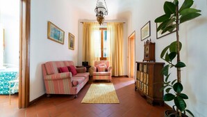 Un salon comprenant un canapé, un fauteuil, un meuble en bois et une plante en pot.