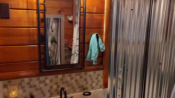 Een bad/douchecombinatie, handdoeken, zeep, shampoo