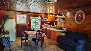 A cozy cabin interior with a dining area, kitchen, and seating space. - Cabin 8 miles from Kings Canyon entrance gate. (Miramonte)