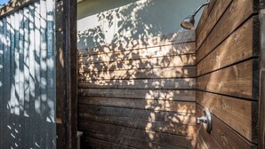 A wooden exterior wall with a metal door and a showerhead. - Cozy Private Beach House - Steps from the beach (Oceanside)