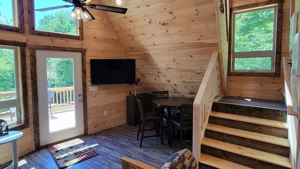 Un intérieur de cabine spacieux, doté d’une grande fenêtre, d’un ventilateur de plafond, d’un coin repas et d’un escalier.