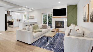 A modern living room with a sofa, coffee table, and fireplace. - Spacious Modern Townhouse w/Private Rooftop Deck (Arvada)