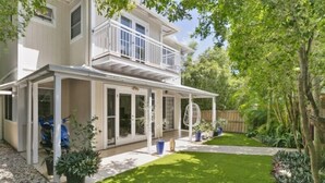 A two-story house with a covered porch, a small garden, and a wooden fence. - Peaceful Family Villa in Sunrise Beach (Sunrise Beach)