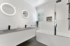 Een bad/douchecombinatie, gratis toiletartikelen, handdoeken