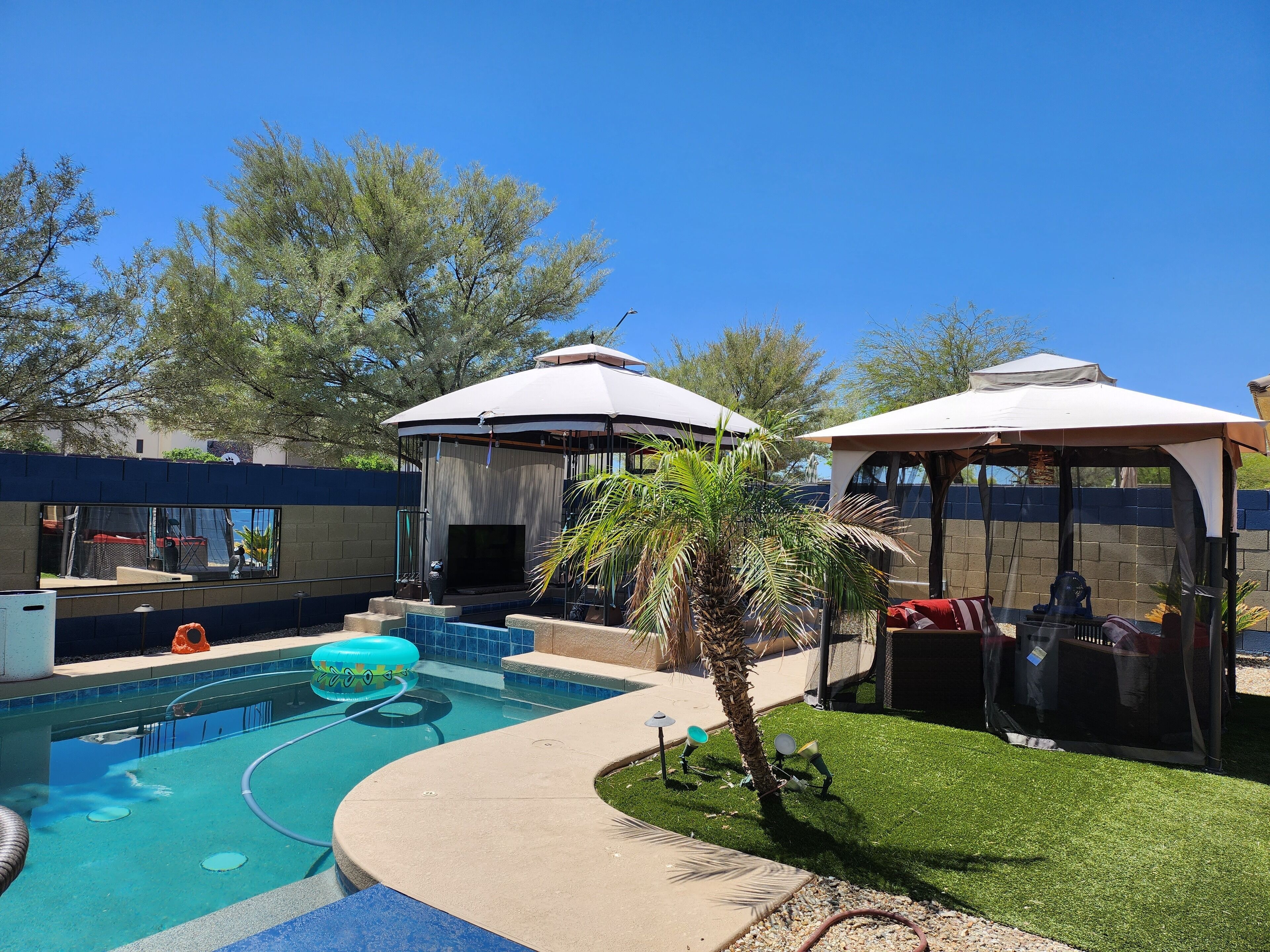 Back yard for entertaining w/ hot tub, heated pool, fire pits, bar & seating