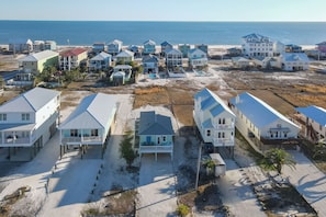 A beachfront residential area with multiple houses, some with balconies and others with attached porches, all featuring a similar architectural style.