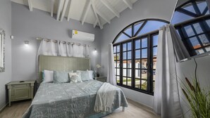 A bedroom with a bed, a nightstand, a window with curtains, and an air conditioning unit. - 4BR4BA Private Pool,Sauna, Putt-Putt & Fire Place (Noord)