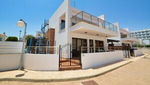 A modern two-story building with a white facade, large windows, and a balcony. - Fabulous Sea view Villa with big luxury Jacuzzi in Protaras, Protaras Villa 1676 (Protaras)