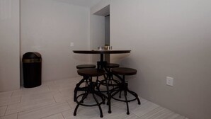 A bathroom with a round sink, three stools, a trash bin, and a mirror. - Iron Horse Carraige Home & Parking (Tucson)