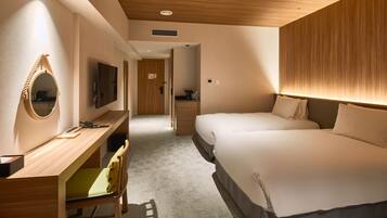 Une chambre d’hôtel avec un bureau en bois, un lit avec une literie blanche et un téléviseur fixé au mur.