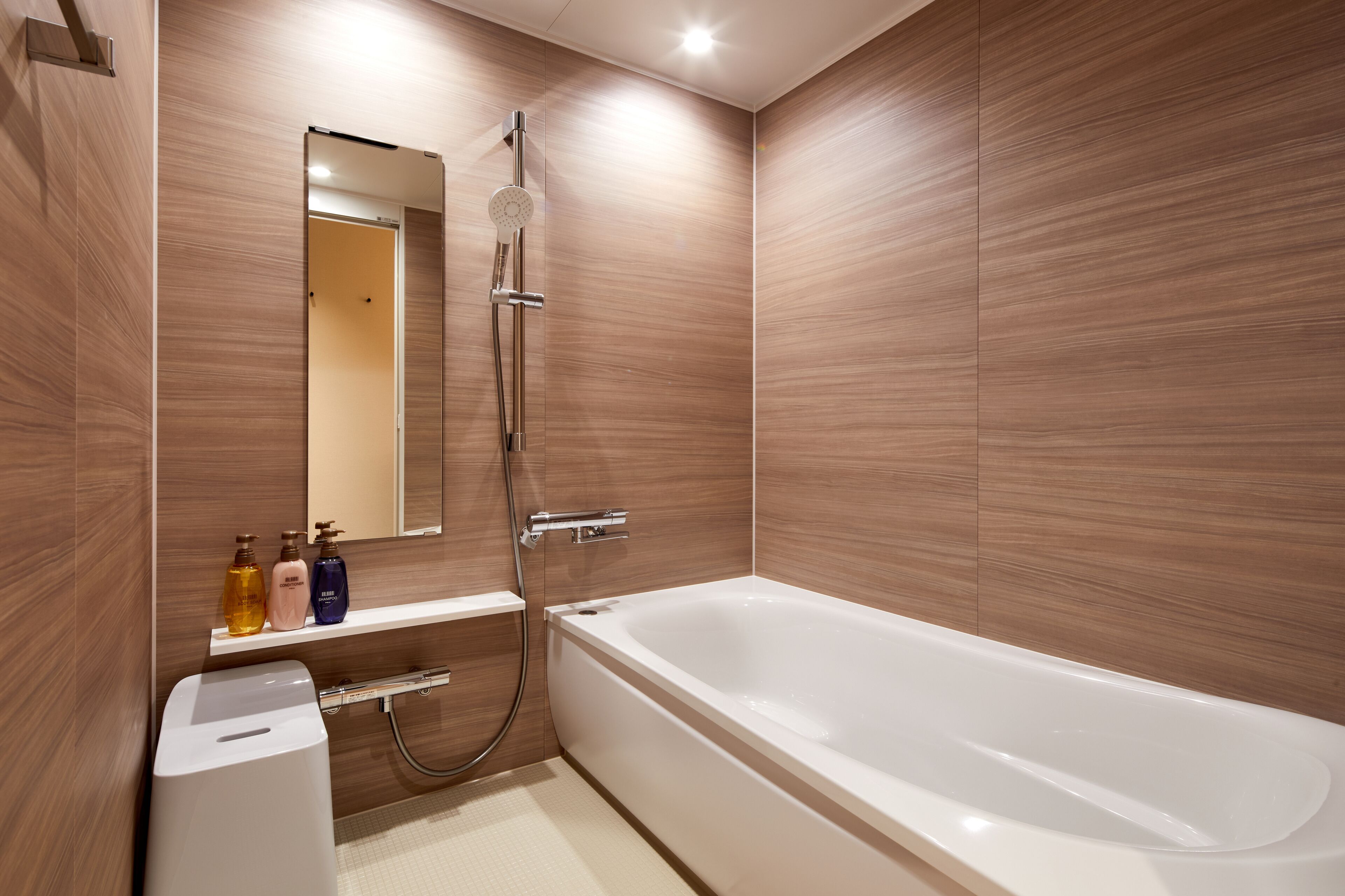 A modern bathroom with a bathtub, a shower, and a vanity with toiletries.