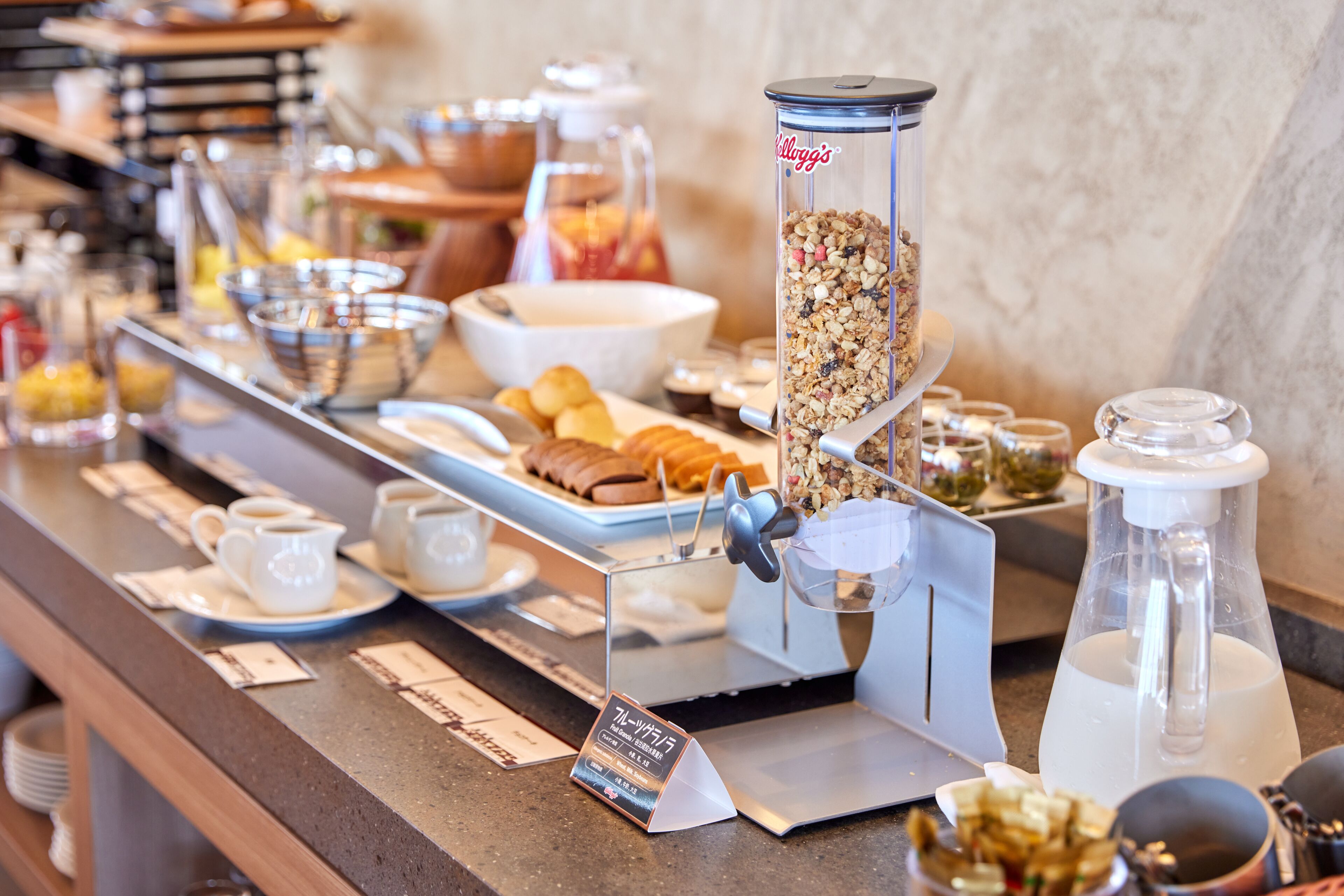Een ontbijtbuffet met diverse soorten eten, zoals ontbijserialen, gebak en drankjes.