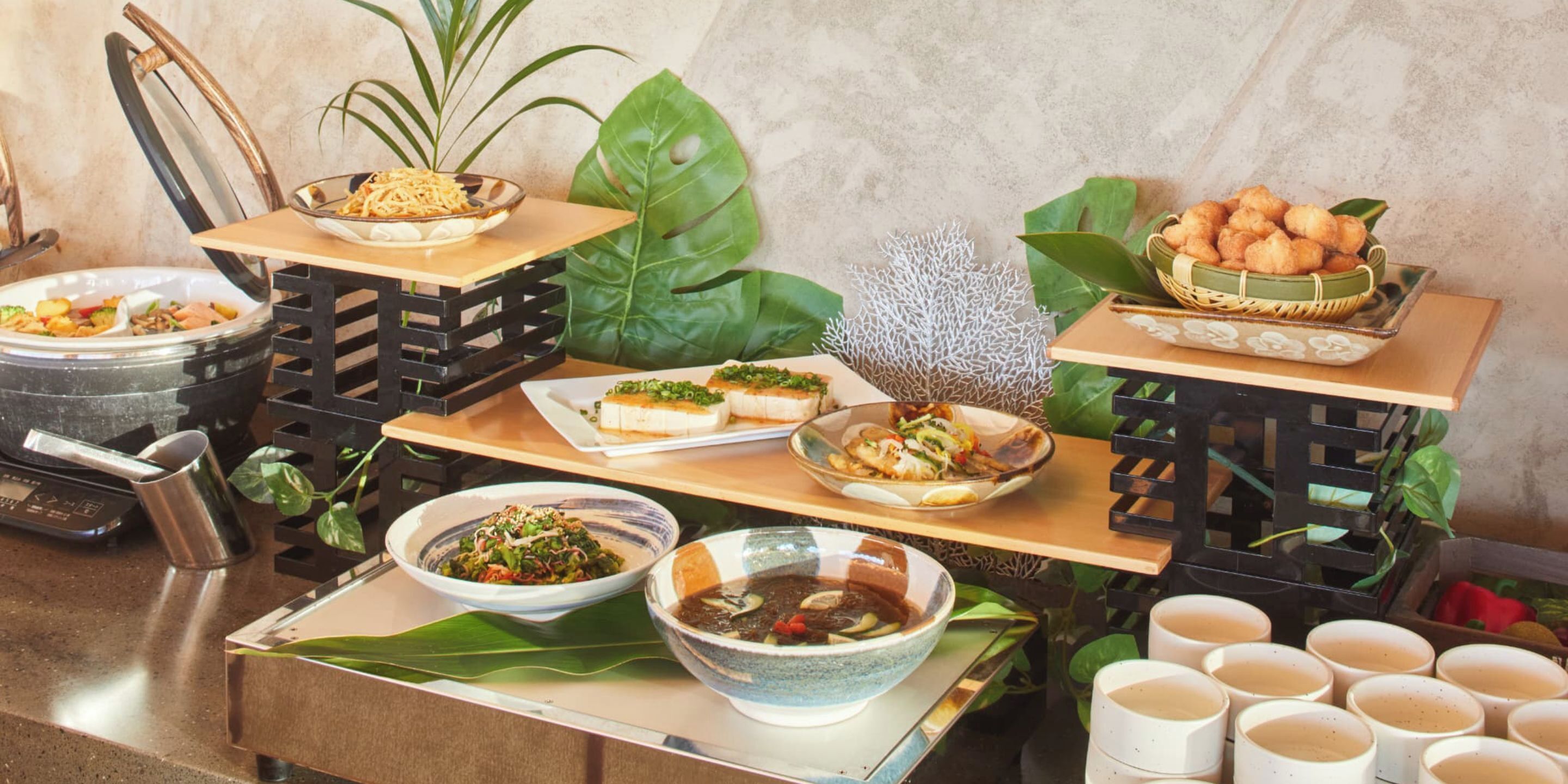A buffet table with various dishes and drinks.