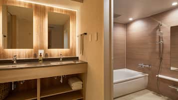 A modern bathroom with a wooden vanity, a large mirror, a bathtub, and a shower.