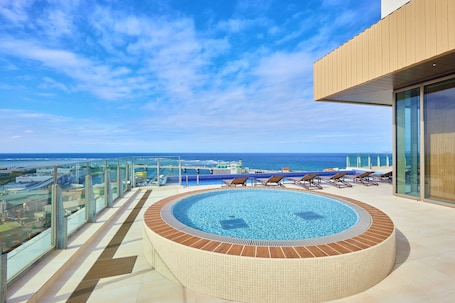 Una piscina al aire libre de temporada, sombrillas