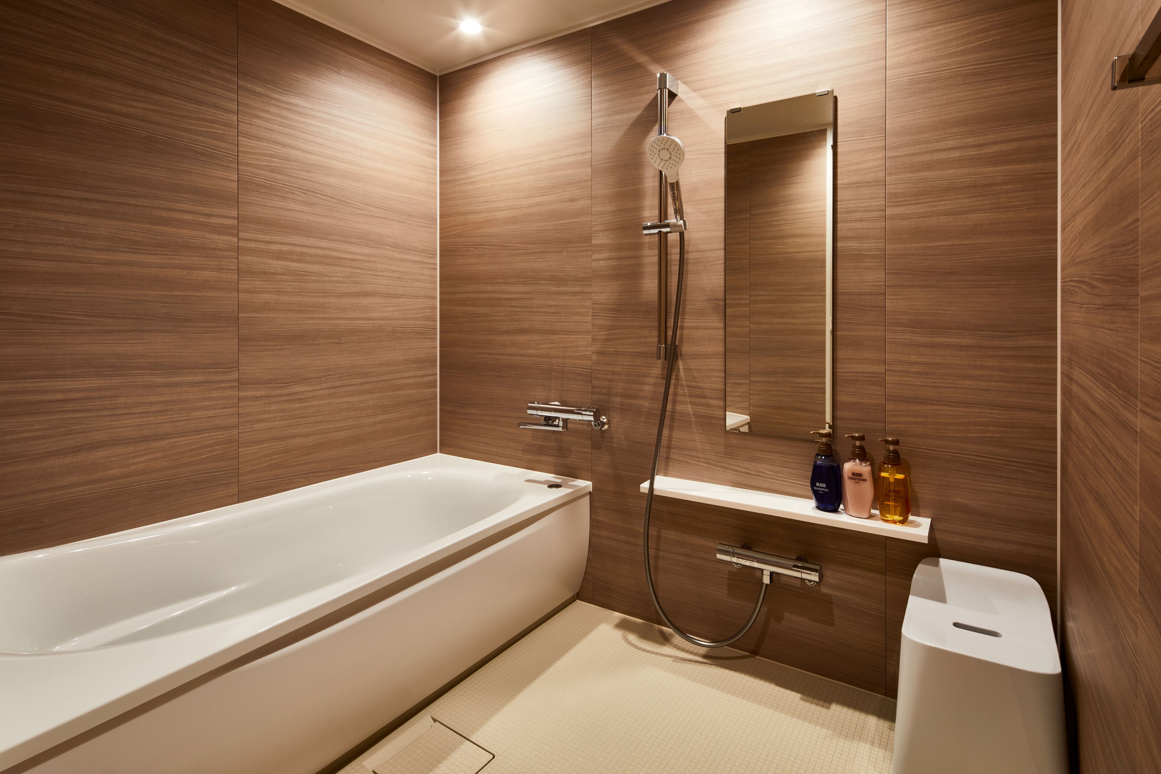 Un baño moderno con bañera, ducha y tocador con espejo.