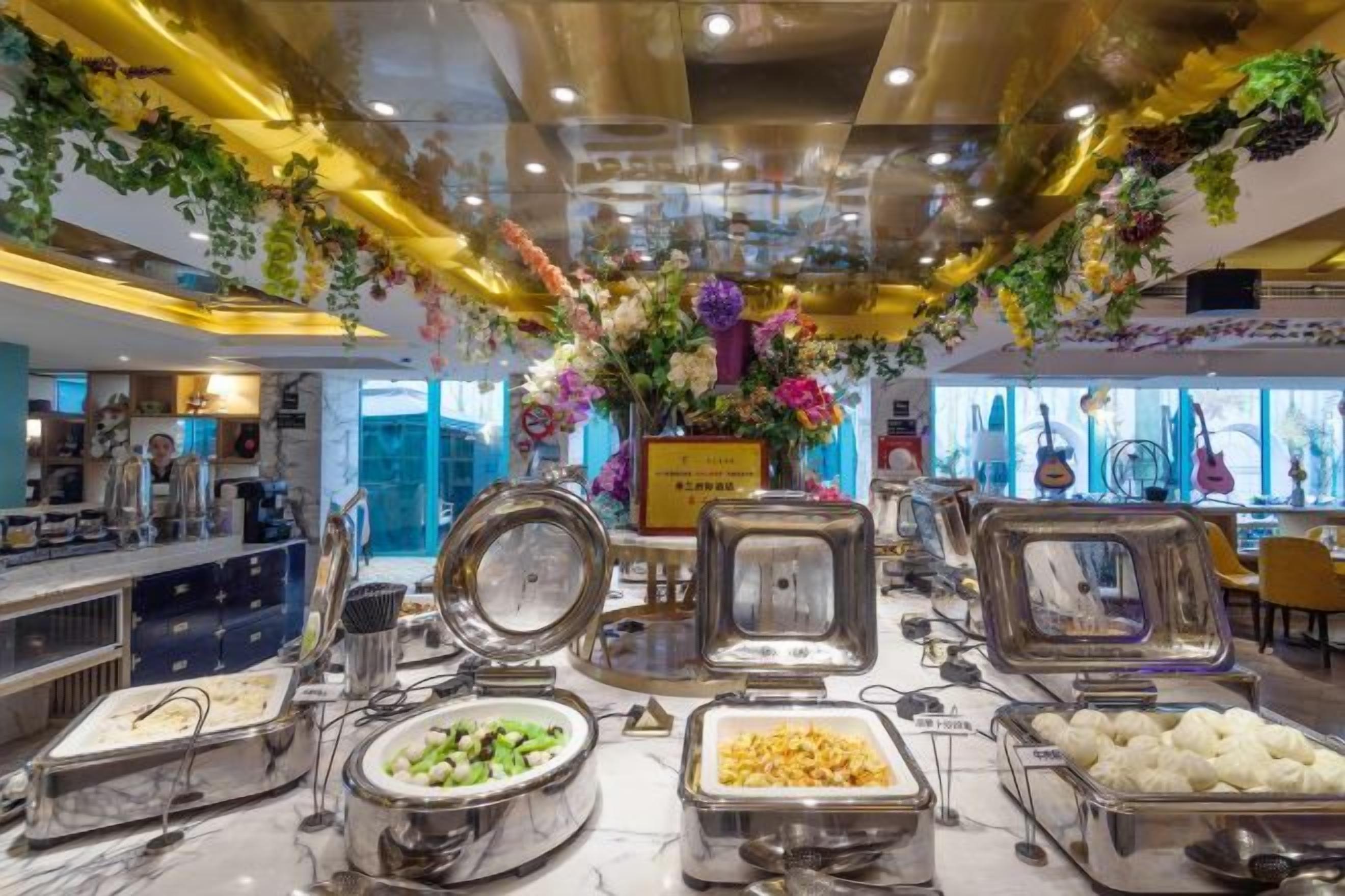A buffet area with various food containers and a decorative floral arrangement.