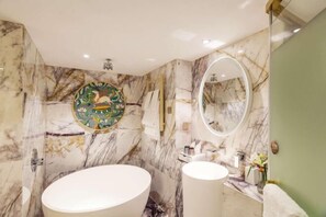 A bathroom with a large oval sink, a round mirror, and a decorative wall piece. - International Milan (Deqing)