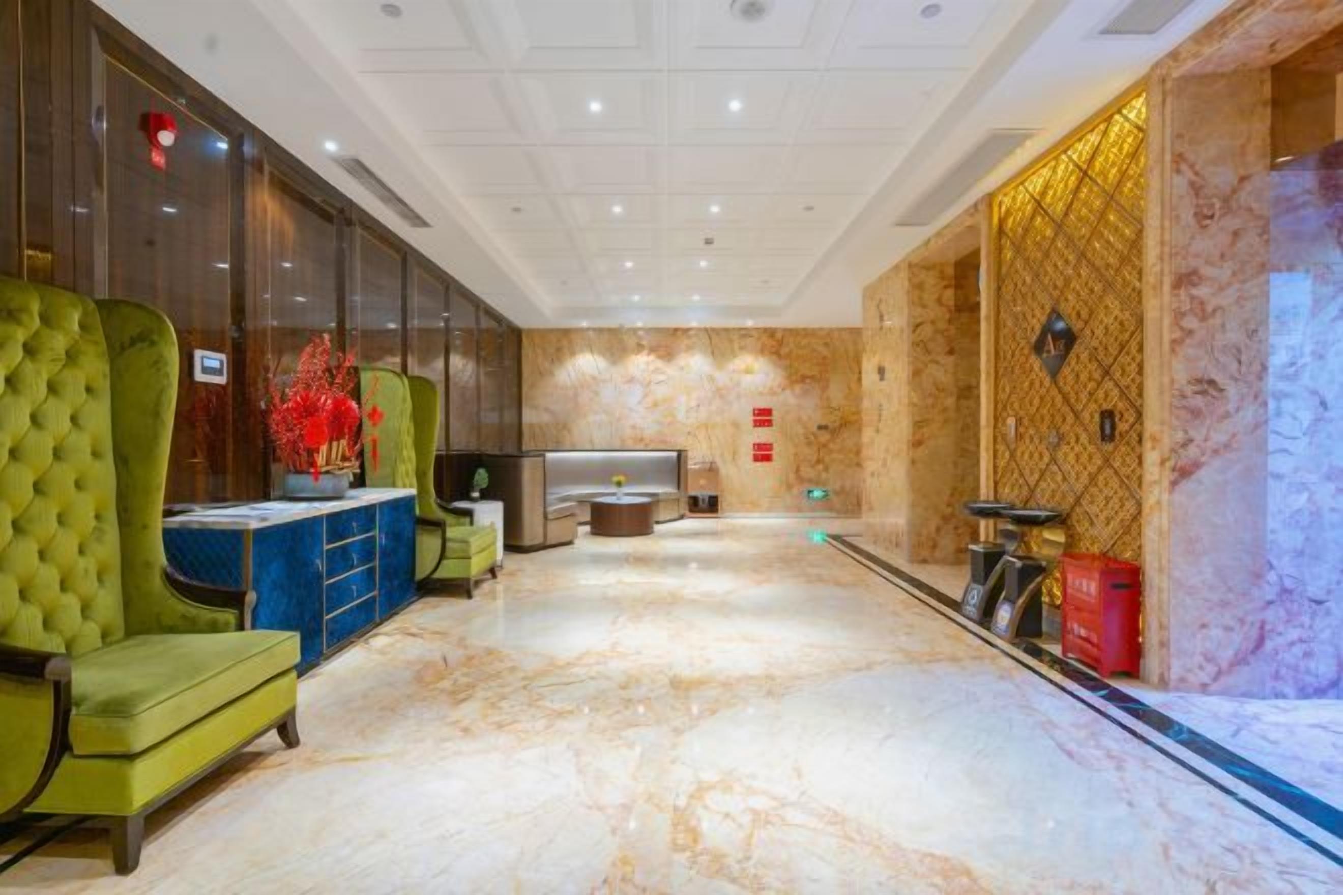 Eine Hotelhalle mit einer Rezeption, einer Sitzecke und einem Marmorboden.