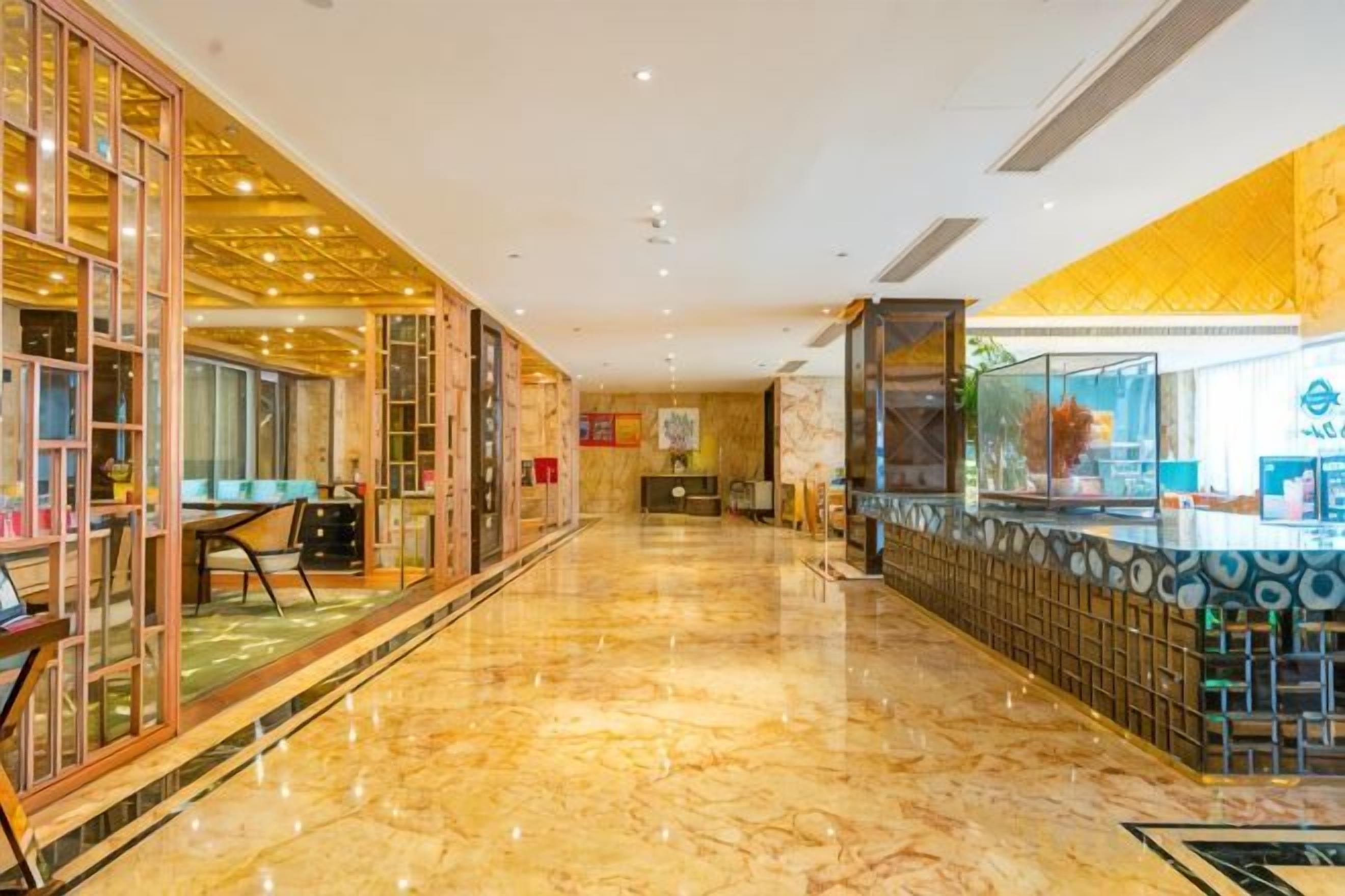 Rebedor d'hotel amb terra de marbre, taulell de recepció i una separació de vidre amb vistes.