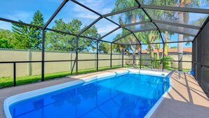 Una piscina con techo metálico y una cerca alrededor.