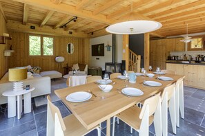 Una cabaña de madera con comedor, cocina y sala de estar.