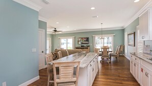 Una cocina amplia con una isla central, sillas de madera y una mesa de comedor.