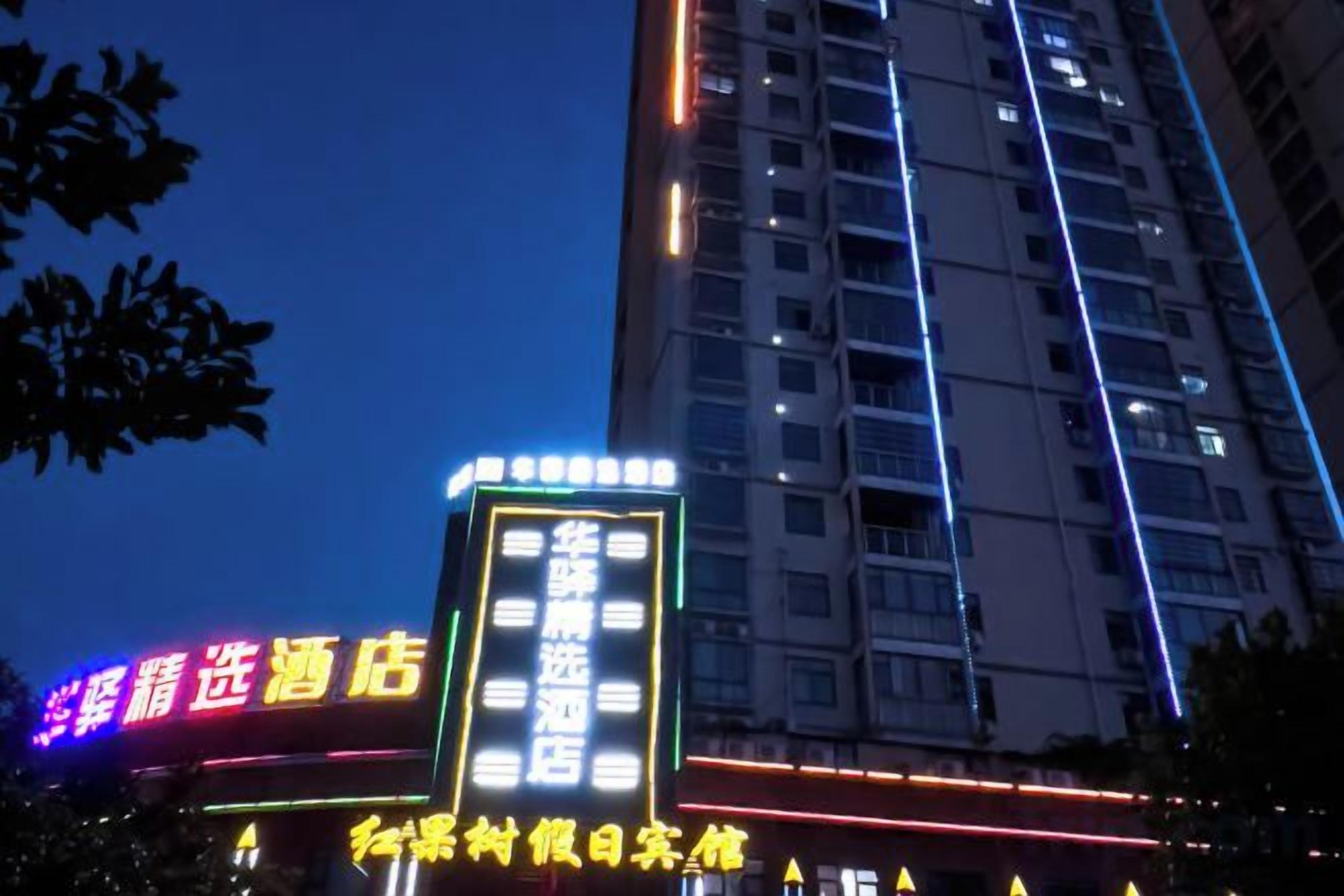 A multi-story building with illuminated signage, including a hotel and a restaurant.