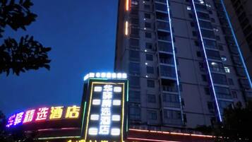 A multi-story building with illuminated signage, including a hotel and a restaurant.