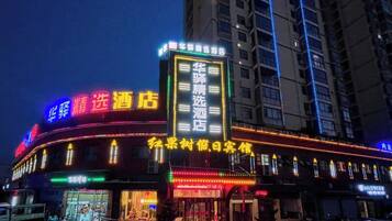 A hotel with illuminated signage, multiple floors, and a prominent entrance.