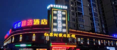 Un hôtel doté d’une enseigne lumineuse, de plusieurs étages et d’une entrée imposante.